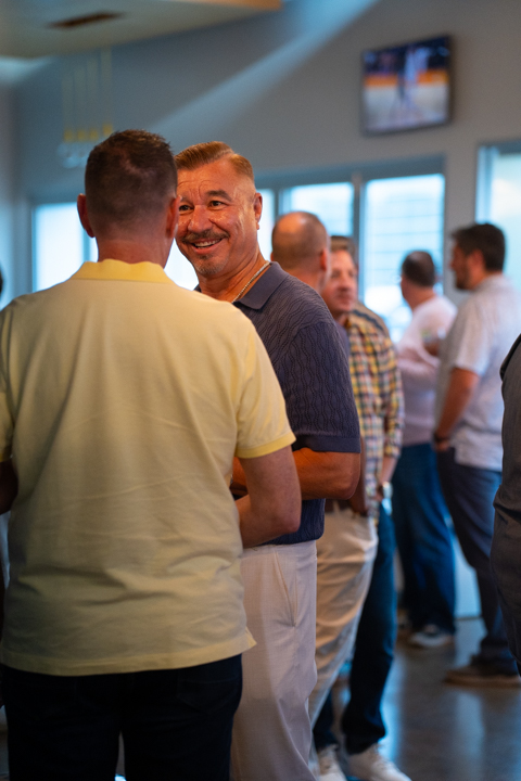 Two guests smiling at each other in a crowded room